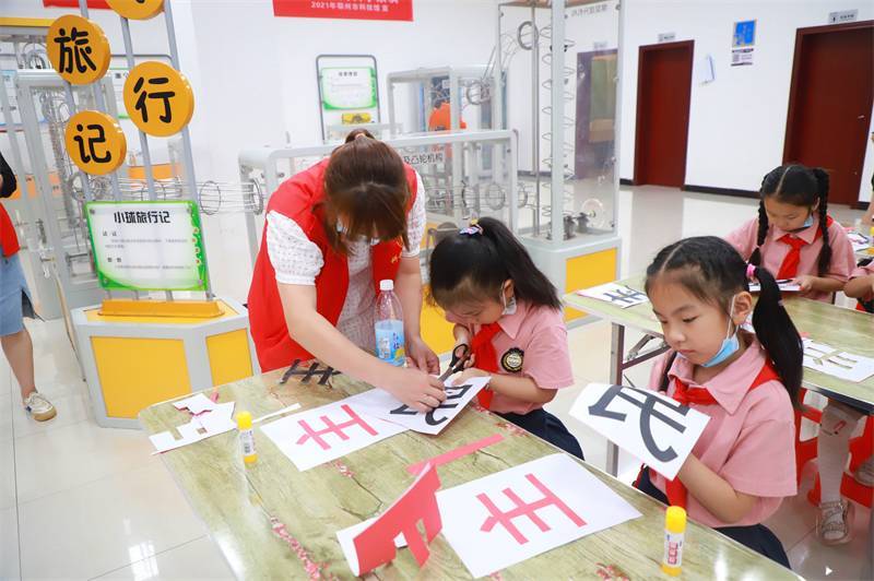 2021年7月10日，鄂州市科協(xié)組織落駕坪小學(xué)學(xué)生在鄂州市科技館開展社會(huì)主義核心價(jià)值觀系列活動(dòng)，圖為開展的紅色剪影圓夢(mèng)中華剪紙活動(dòng)，志愿者指導(dǎo)同學(xué)們.jpg