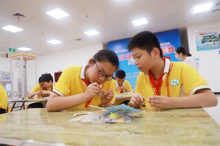 2021年7月9日鄂州市科協(xié)組織新民街小學(xué)學(xué)生在鄂州市科技館開展社會(huì)主義核心價(jià)值觀系列活動(dòng)，圖為開展的科技創(chuàng)新圓夢中華科技小制作活動(dòng)，孩子們正在相互配合制作蠕蟲機(jī)器人.jpg
