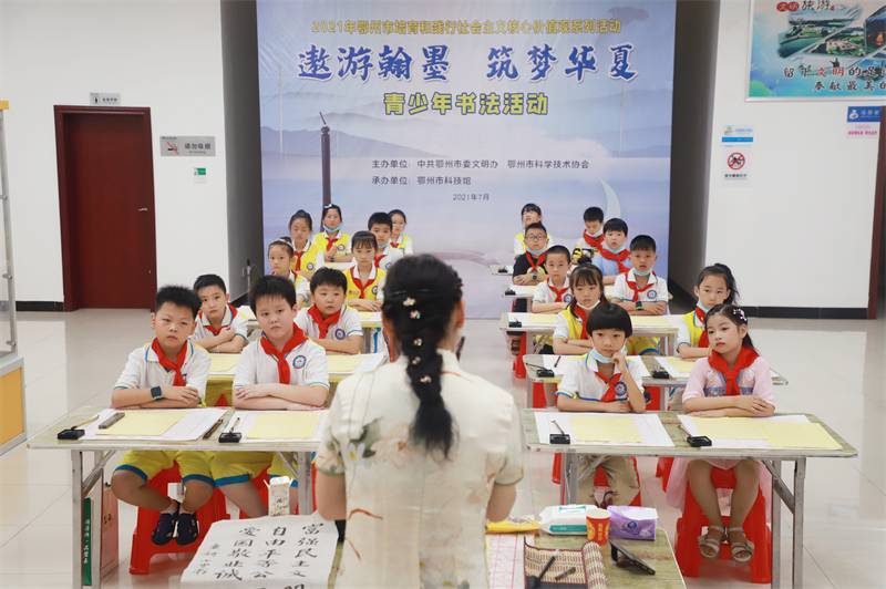 2021年7月10日，鄂州市科協(xié)組織蓮花小學學生在鄂州市科技館開展社會主義核心價值觀系列活動，圖為開展的遨游翰墨筑夢華夏書法活動，老師講解握筆姿勢2.jpg