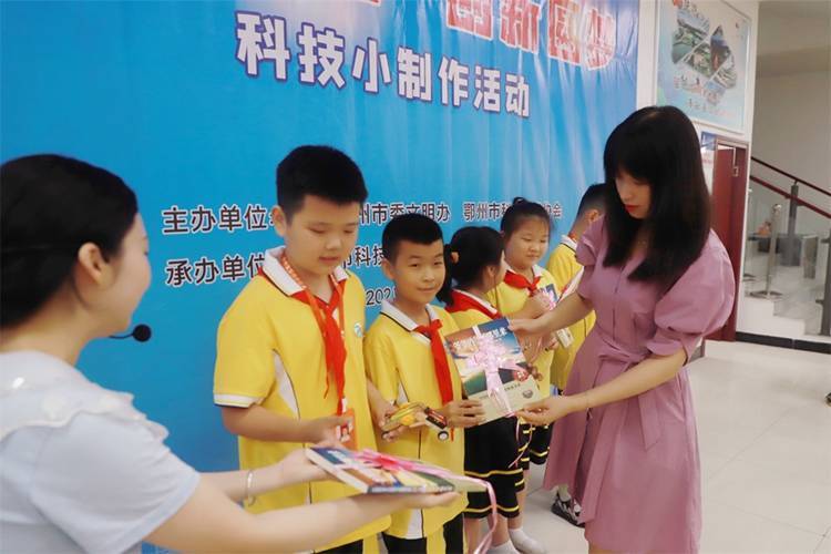 2021年7月9日鄂州市科協(xié)組織新民街小學(xué)學(xué)生在鄂州市科技館開展社會(huì)主義核心價(jià)值觀系列活動(dòng)，圖為開展的科技創(chuàng)新圓夢中華科技小制作活動(dòng)，科協(xié)王雨濛部長正在為優(yōu)先制作完成的學(xué)生頒發(fā)獎(jiǎng)品.jpg